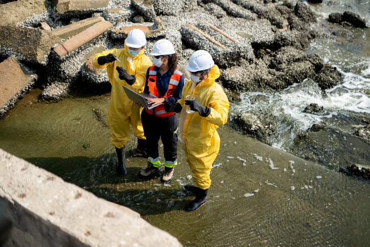 workers near water edge wearing PPE