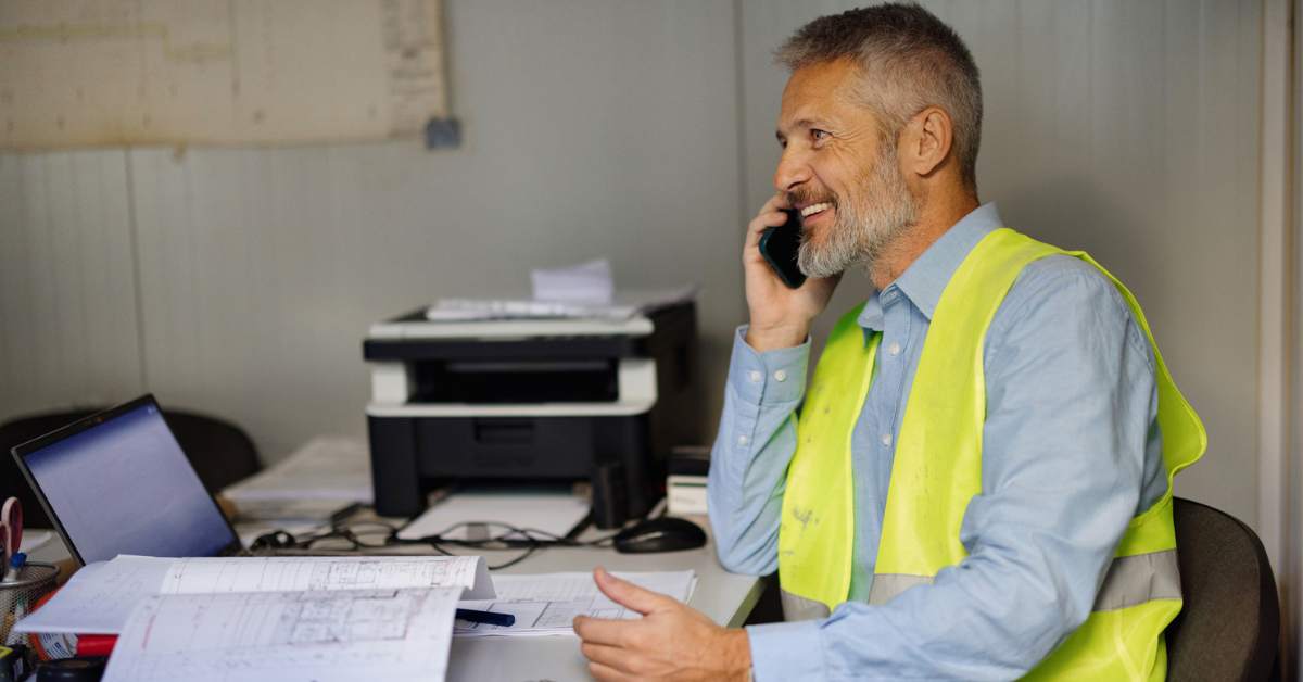 construction business owner talking on phone at desk