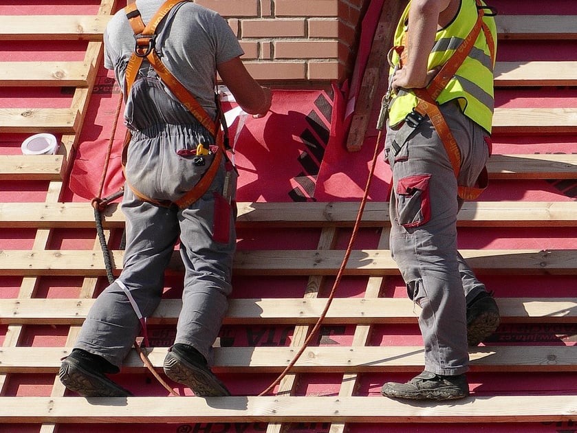 men working on roof with safety gear