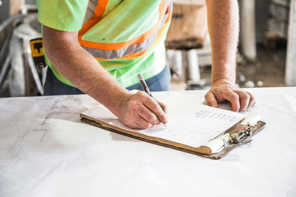 Construction foreman writing on a clipboard